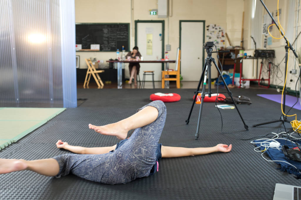 Movement Alphabet by Jan Lee and Tim Murray-Browne, interactive participatory installation mapping body movement into generative visuals. Jan lying on floor with Kinect in background during artistic residency at GAS Station, East London